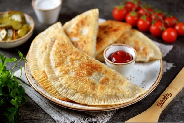 Meat chebureki in a frying pan