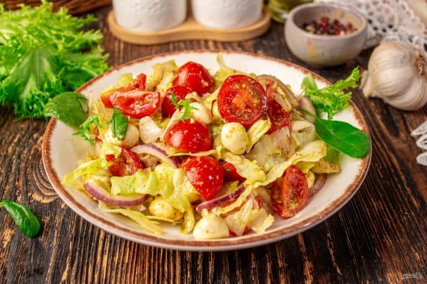 Salad with cherry tomatoes, mozzarella, and pesto sauce