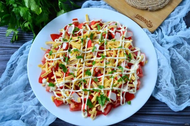 Salad with tomatoes, crab sticks, cheese, and garlic