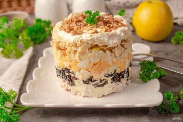 Layered salad with chicken, prunes, apple, and nuts